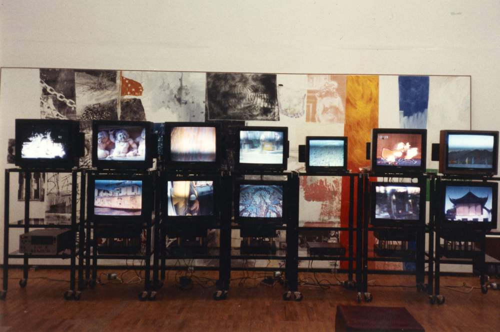 Installation of television monitors displaying video footage from countries visited during the ROCI tour at ROCI USSR, Central House of Artists. Work shown in background is Colonnade (Salvage) 1984.