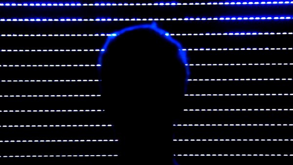 image of a sillhouette of a persons head against the rows of lights