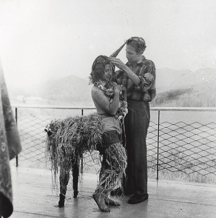 Robert Rauschenberg en train de dessiner un costume de mardi gras pour sa sœur Janet, modelé par sa camarade Inga Lauterstein, Black Mountain College, Caroline du Nord, c1949, photographié par Trude Guermonprez.