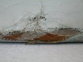 Detail showing torn canvas attached to strainer bar with paint