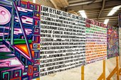 close up of a series of text based paintings on wooden slats