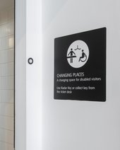 a changing places toilet sign printed on the wall.