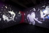 Installation view of a room with projected images on the walls