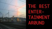 A split image with a view from a train or car showing electricity pylons on the left and red text on a black background on the right. The text says 'The Best Entertainment Around'.